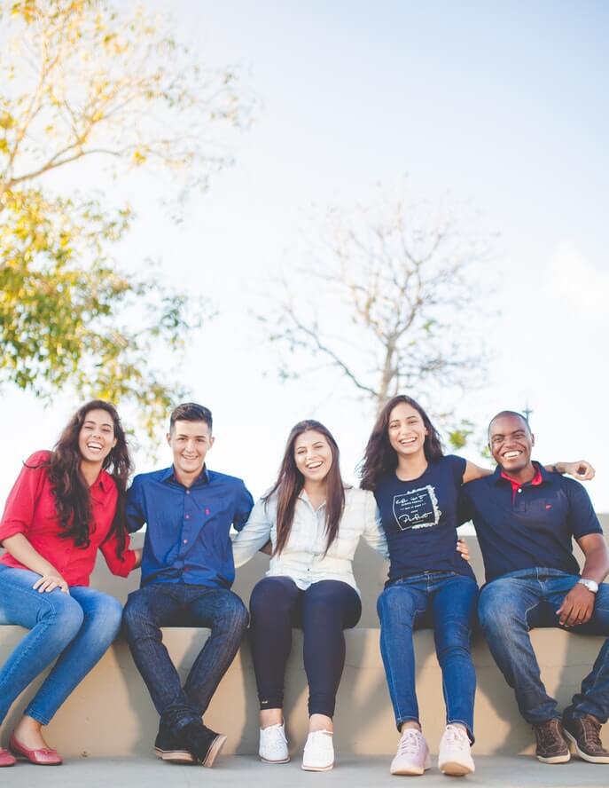Image of five friends sitting down for a photo.