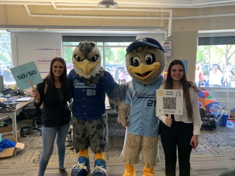 Members of Launch57 posing with the Riverhawks mascot